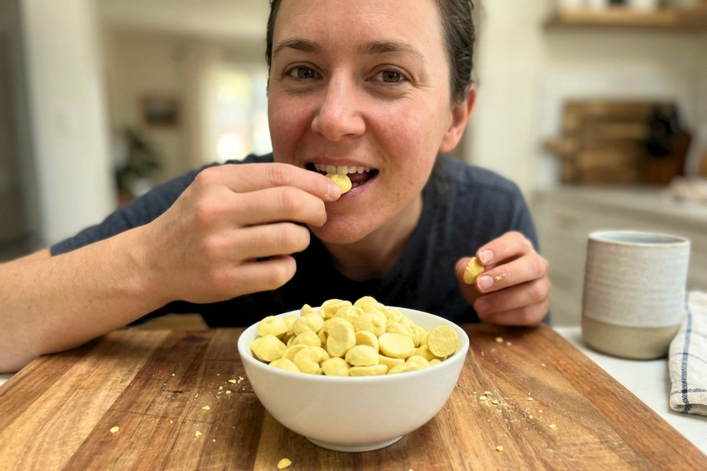 Person eating Organic Mango Coconut Smoothie Drops to smoothie bowl